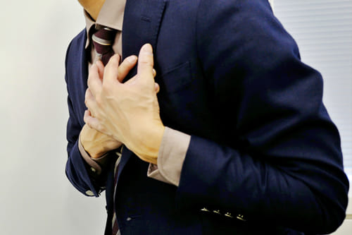 心臓を押さえる男性