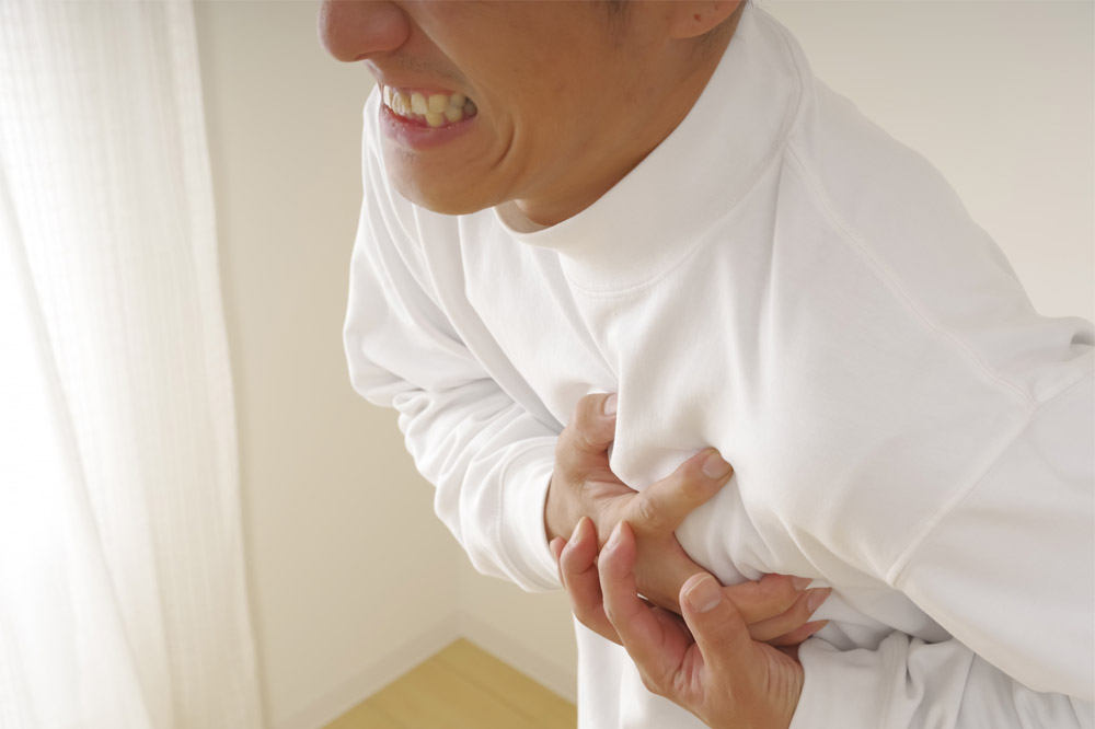 胸を押さえる男性