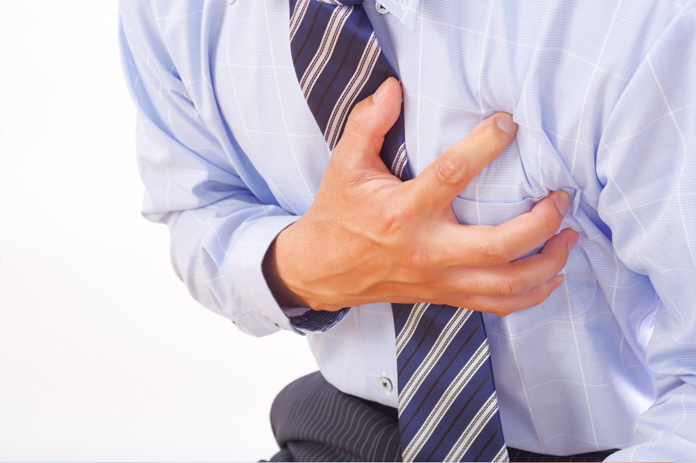 心臓を押さえる男性